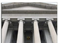 AGTA Continues the Fight for Zero Tariffs: Thailand and Vietnam Look to be Next Two people standing in front of large classical columns outside a building.