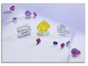 The Final Rio Tinto Beyond Rare™ Tender! Rare Pinks, a Red, a Dozen Fancy Violets, a Yellow and a couple of D-Flawless Diaviks A collection of colorful gemstones scattered on a white surface.