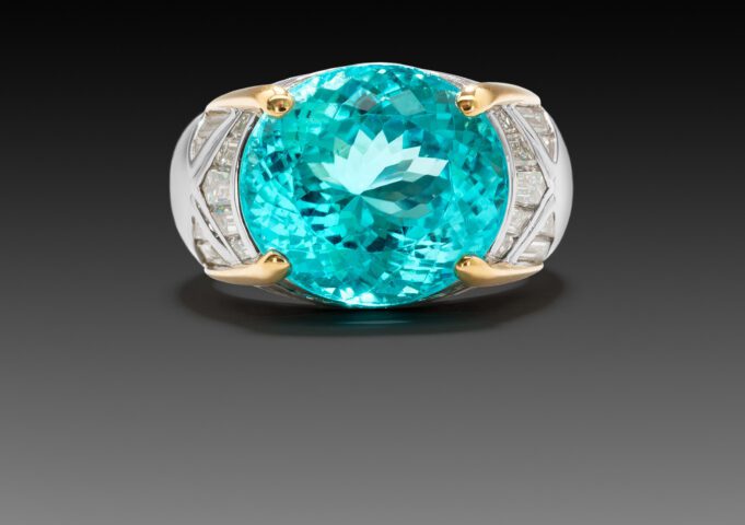 Elegant ring with a large blue gemstone and gold accents.